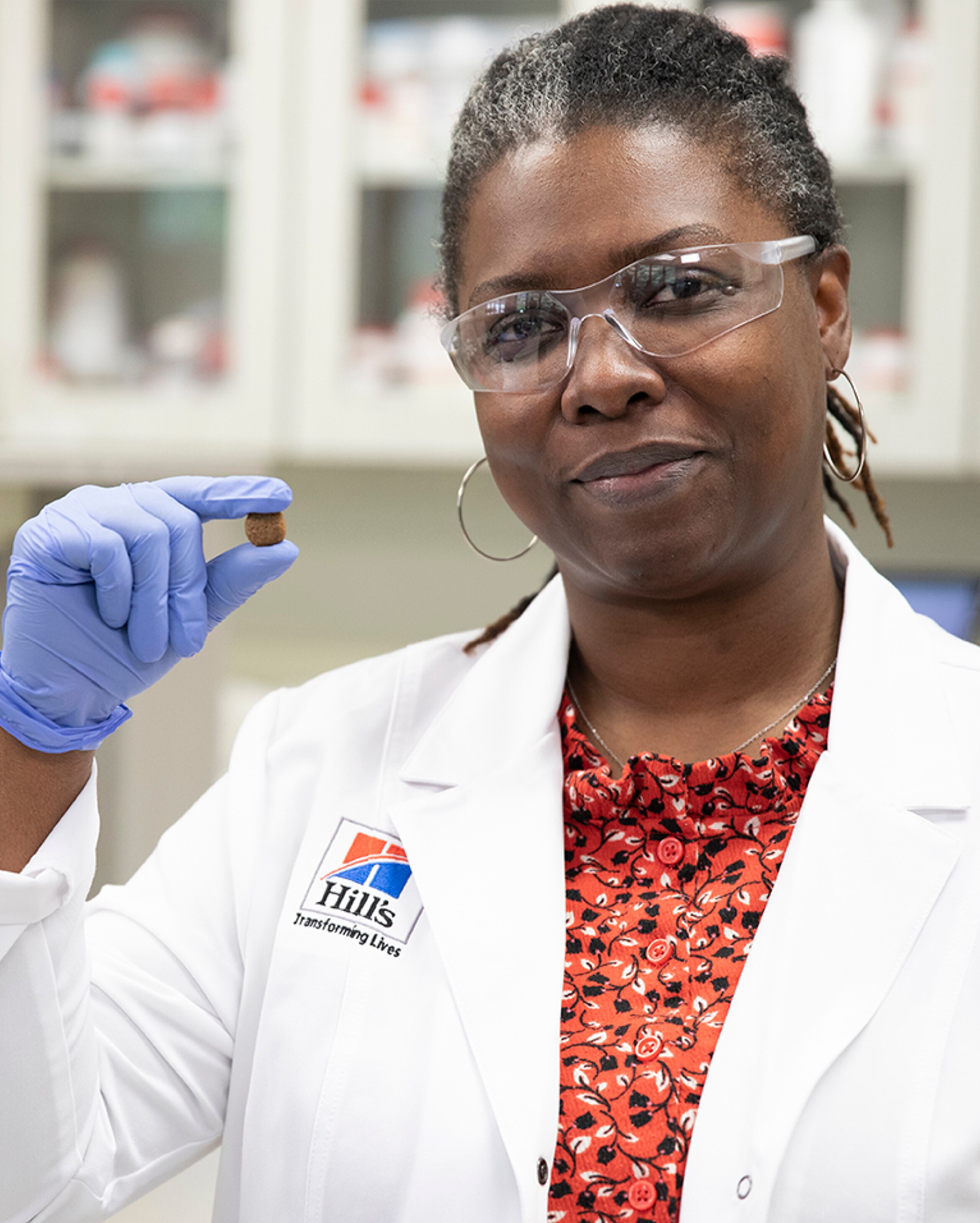Hill's research scientist holding one piece of kibble