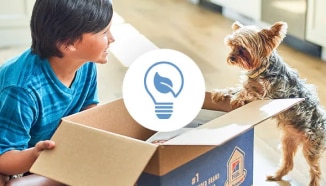 A young boy and a dog looking at recyclable Hill’s box
with a reducing waste icon on it